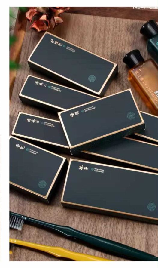 Charcoal hotel amenity boxes arranged on a wooden table